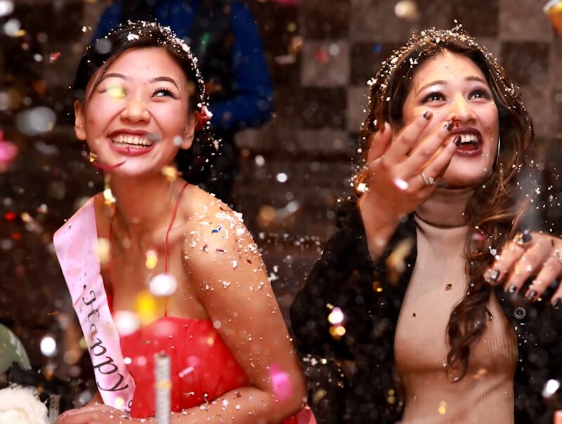 time-lapse photography of two women splashing glitters