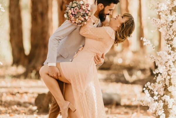 wedding couple surrounded by pink petaled flowers