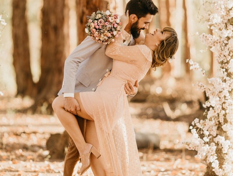 wedding couple surrounded by pink petaled flowers